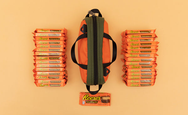 A Texturized Orange Grab Bag with 31 packs of Reese's Cups next to it.